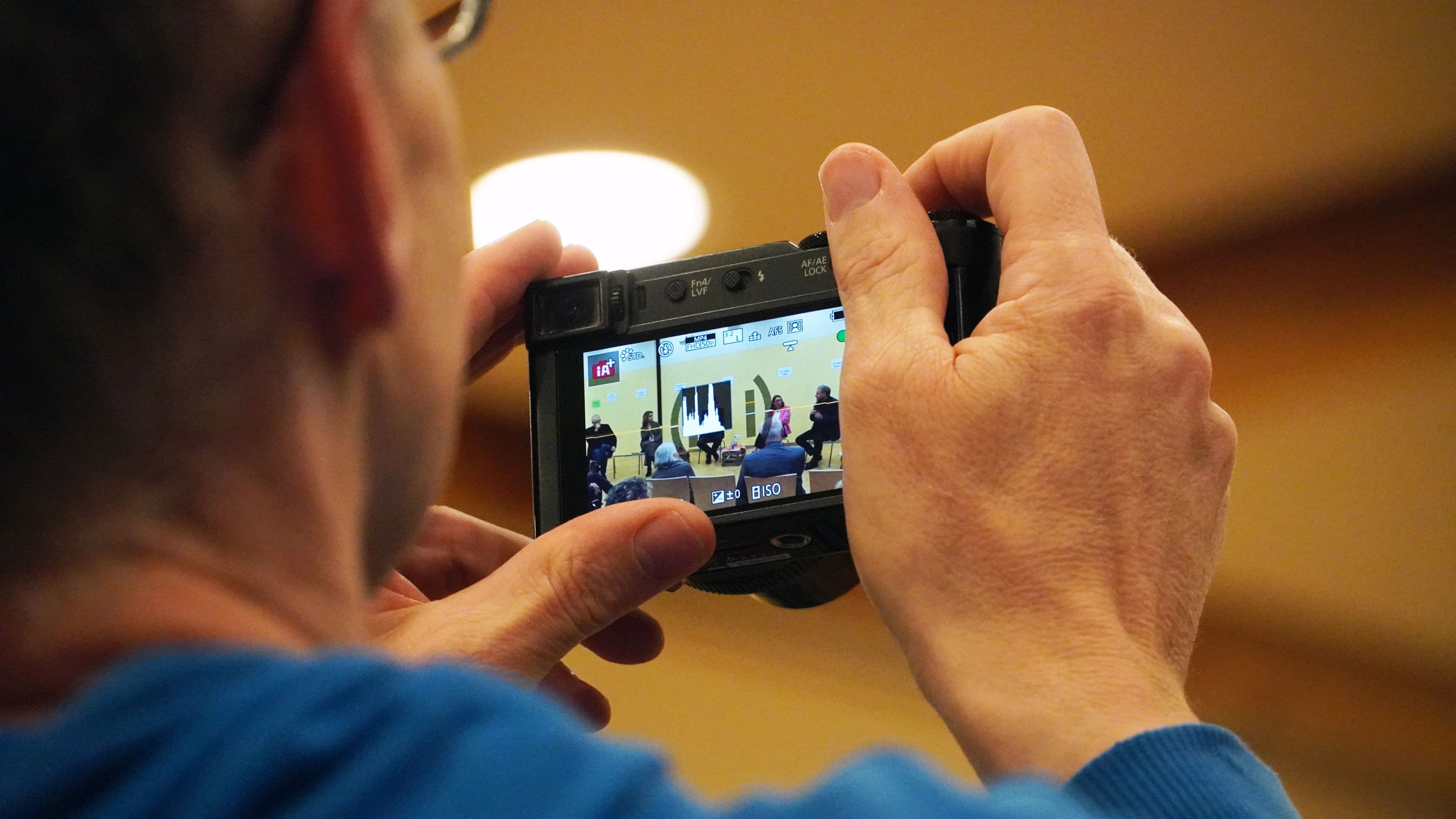 A person takes a photo of the panel discussion at the Cannstatter Forum