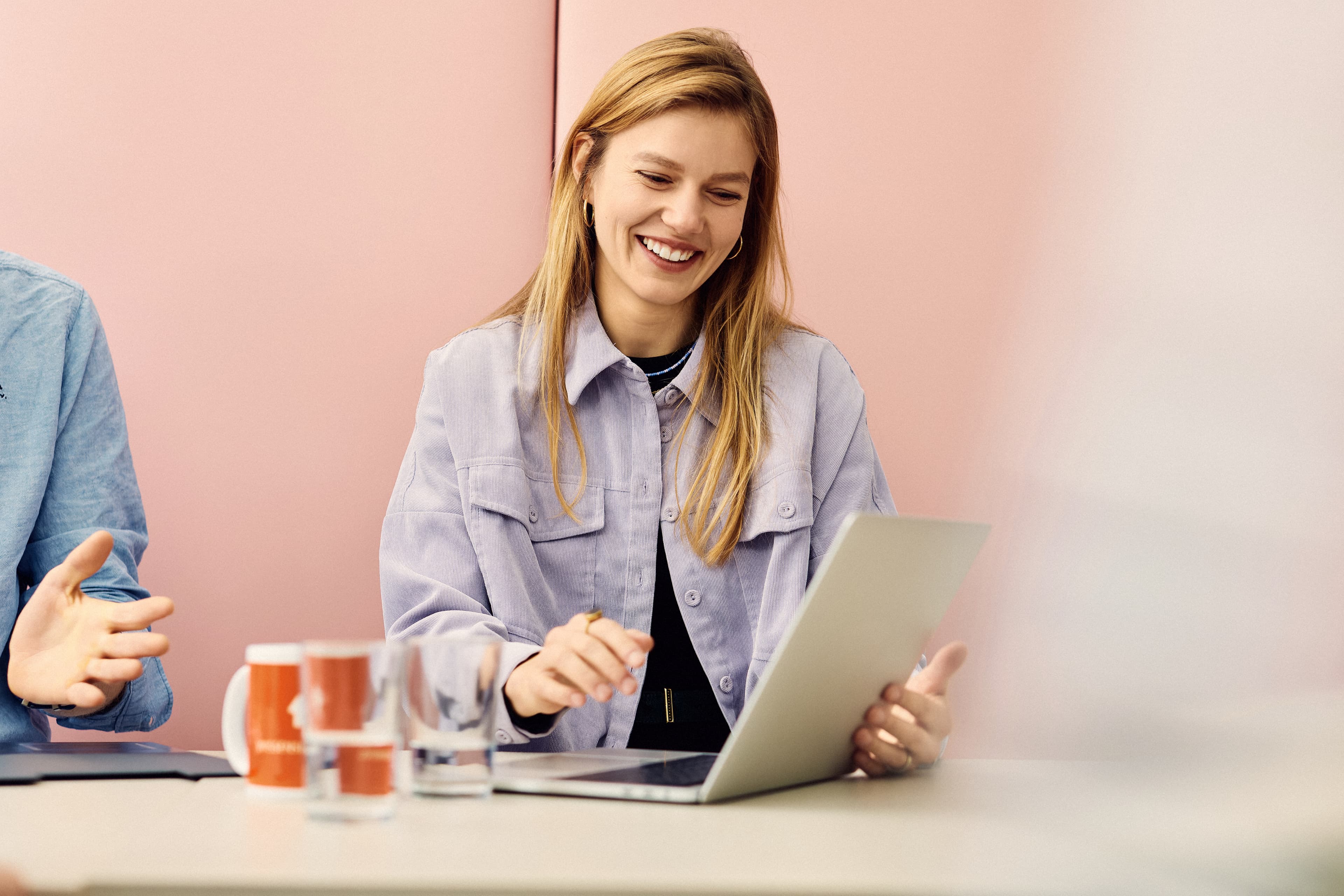 An IWM employee showing her colleagues something on her laptop
