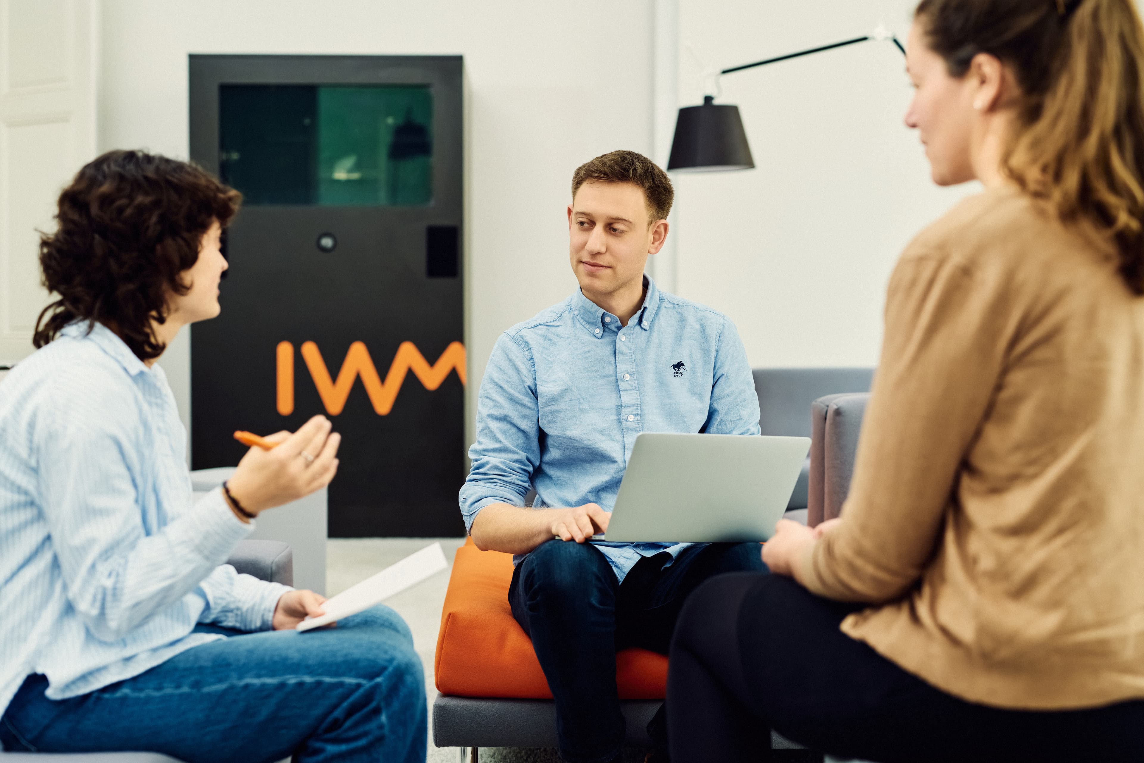 Three IWM employees exchanging ideas and taking notes