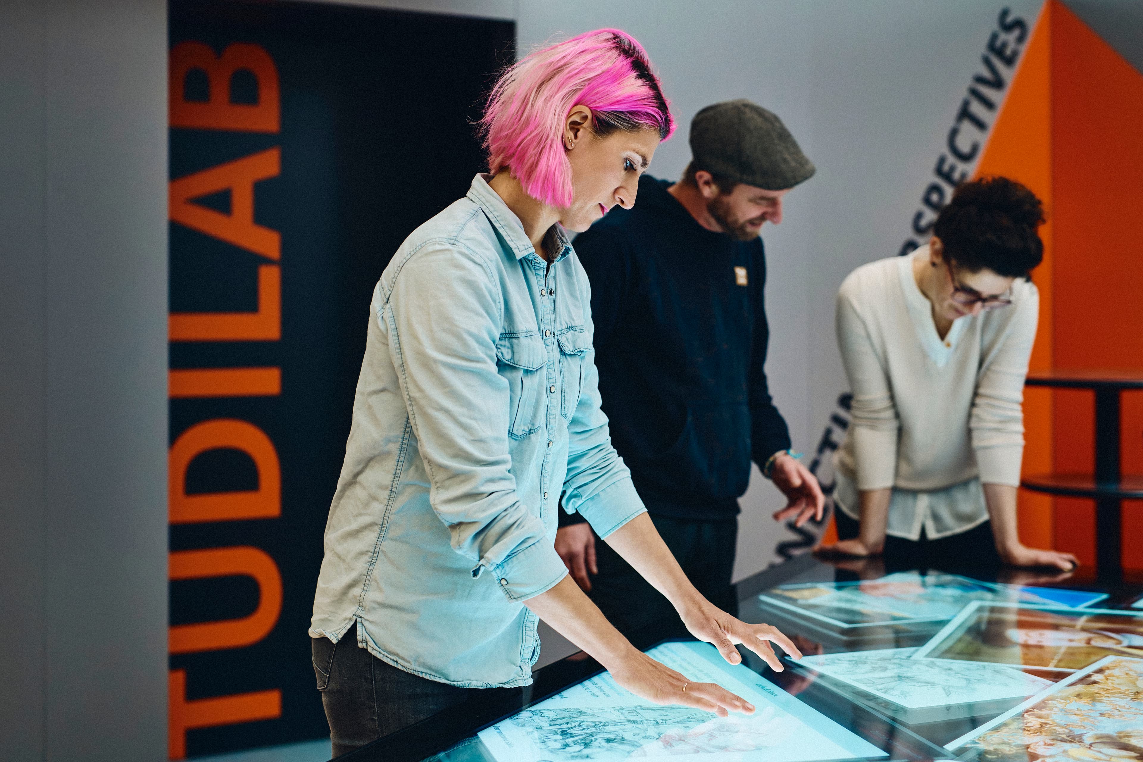 Several people using a multi-touch table in front of the TüDiLab