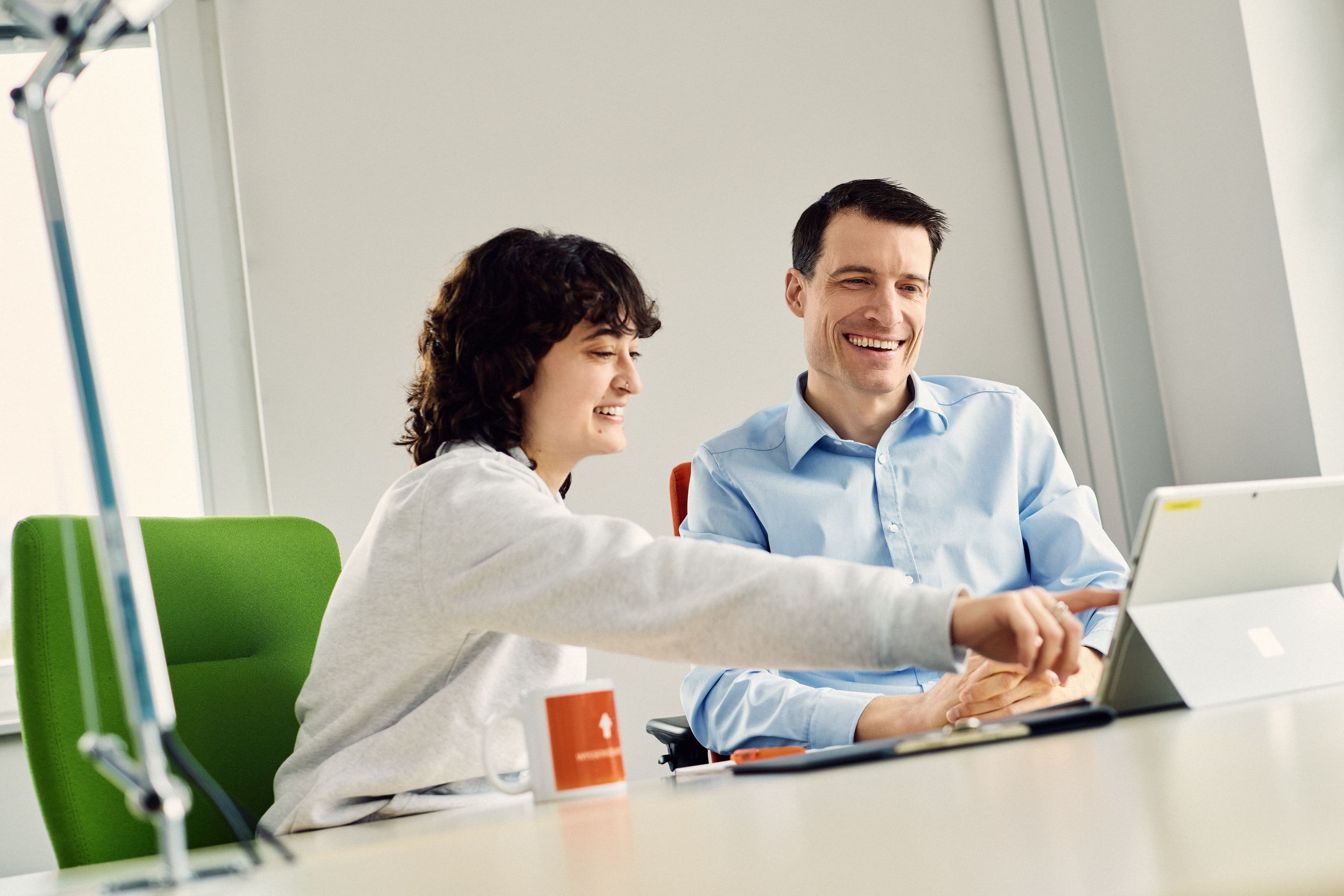Two IWM employees exchanging ideas using a laptop