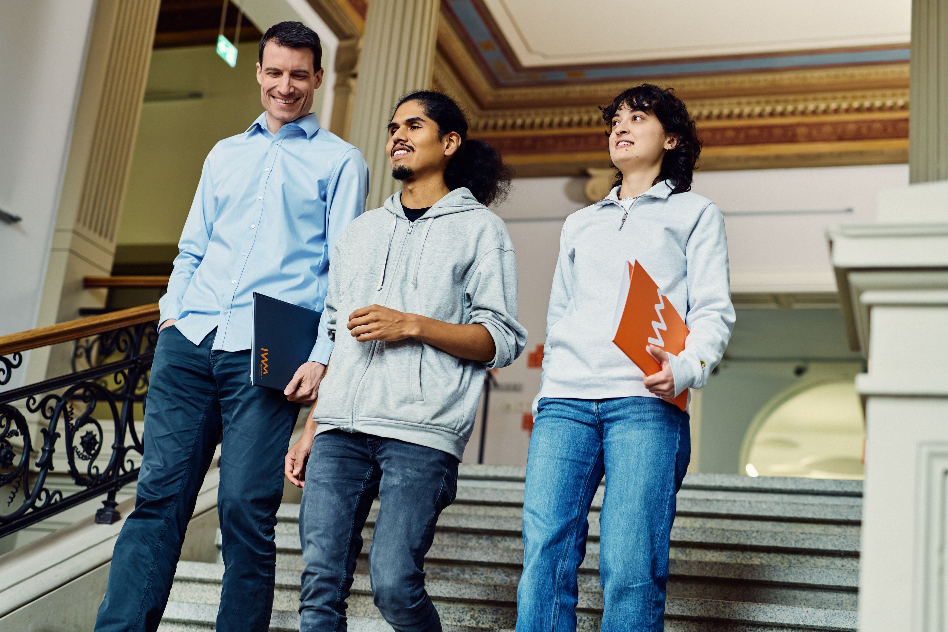 Three IWM employees walking down a stairway together