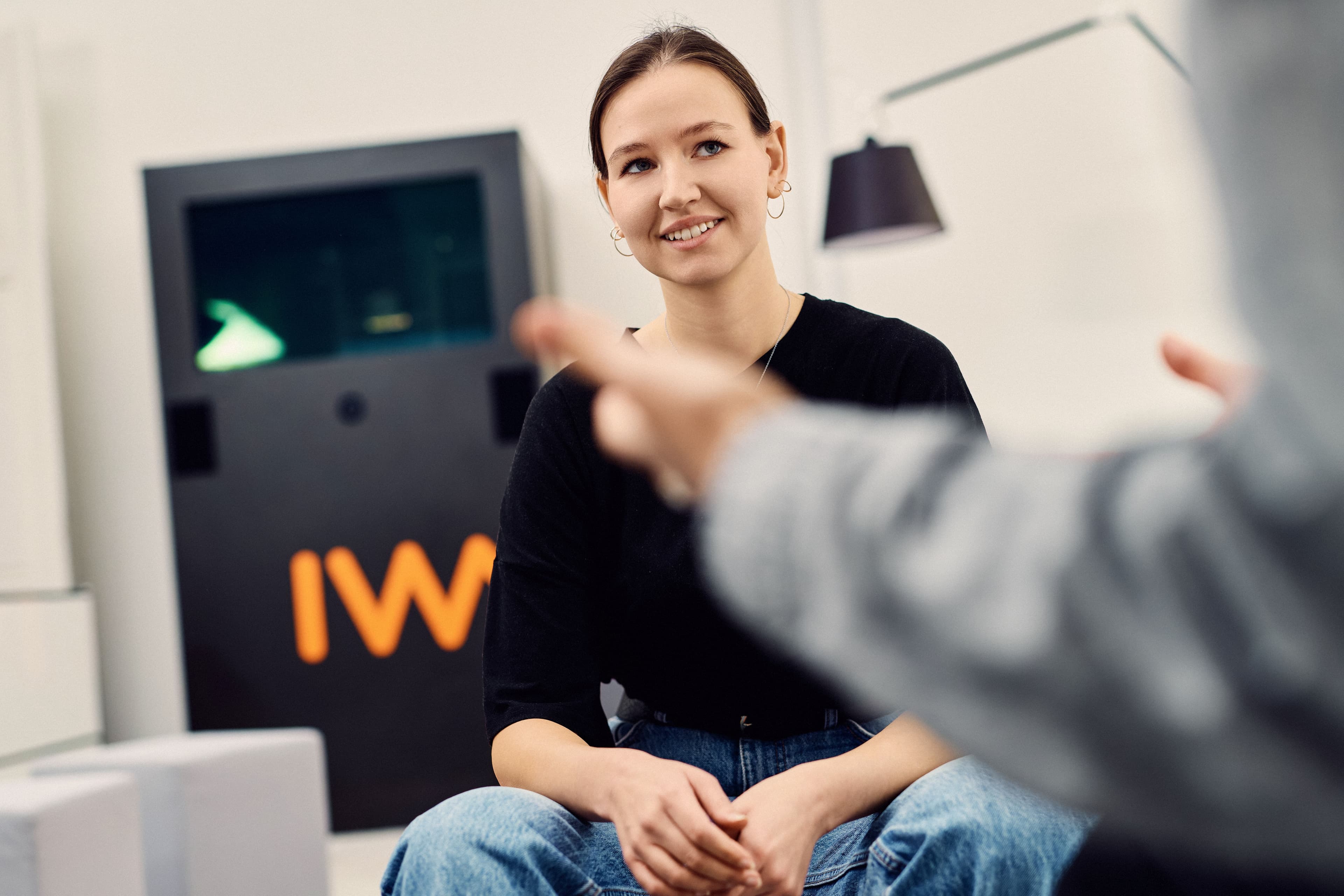 An IWM employee listening to her colleague