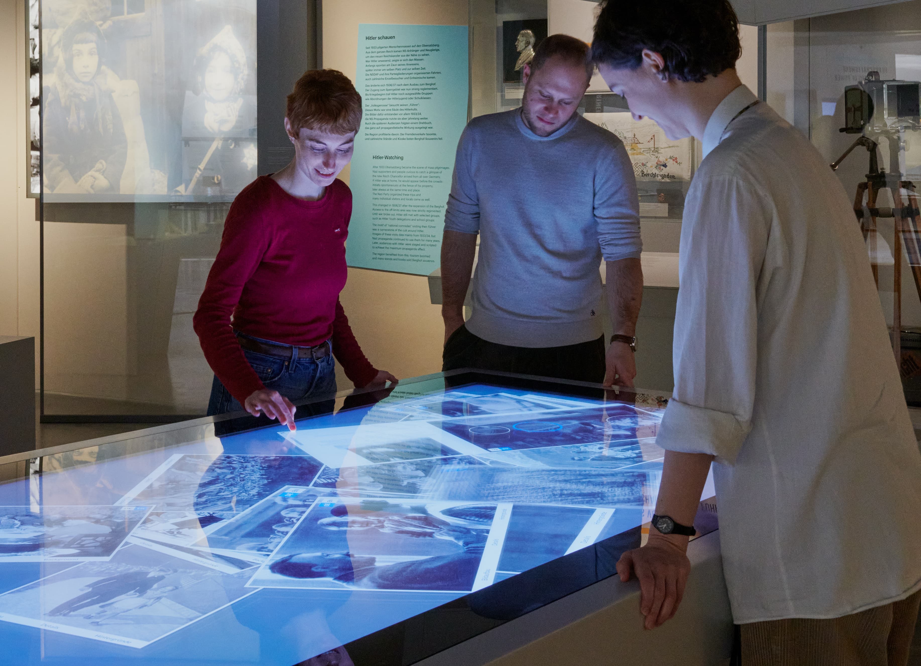 People standing around a multi-touch table, swiping