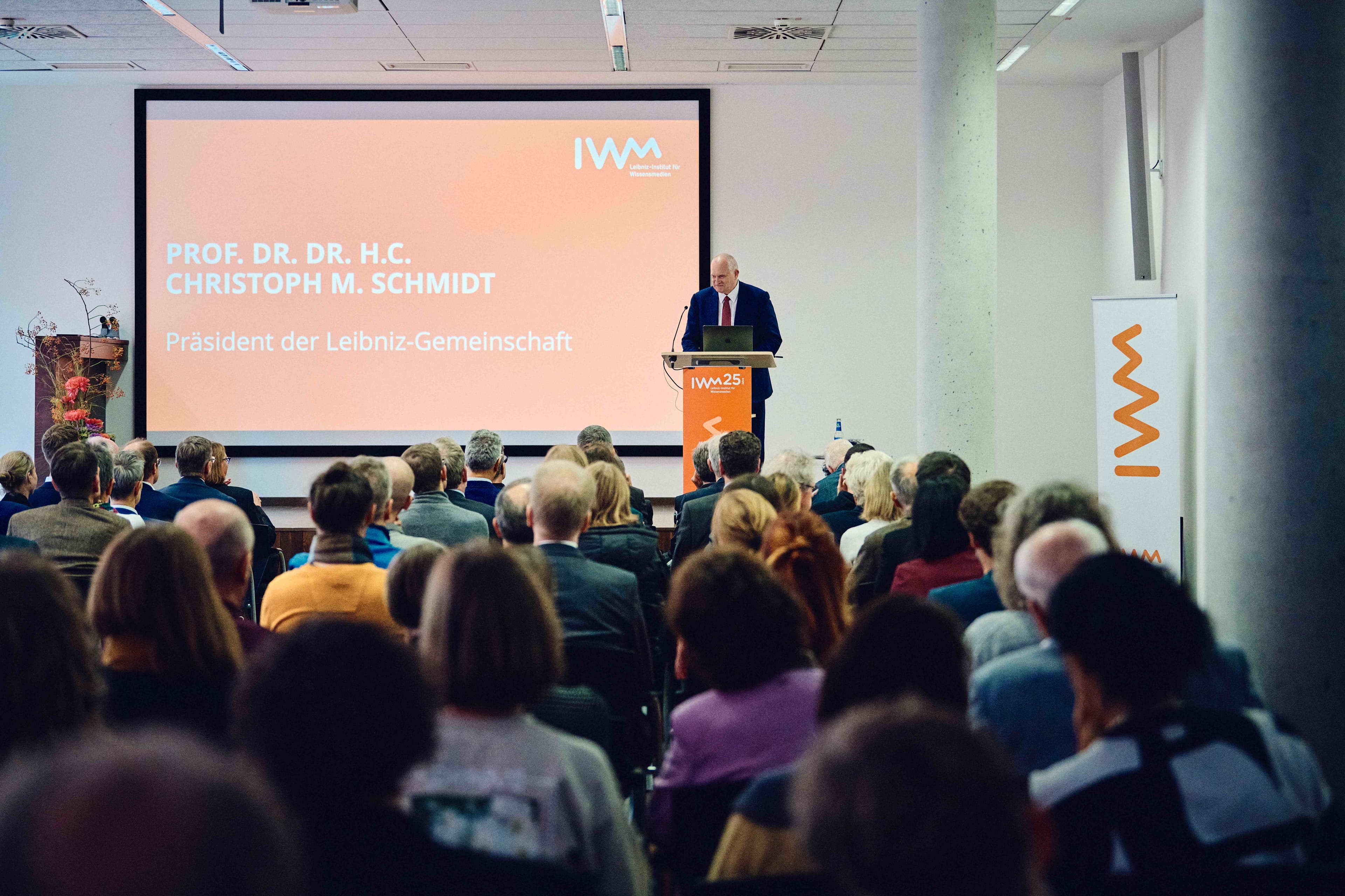 Christoph M. Schmidt speaks at a podium in front of the audience during the IWM anniversary celebration