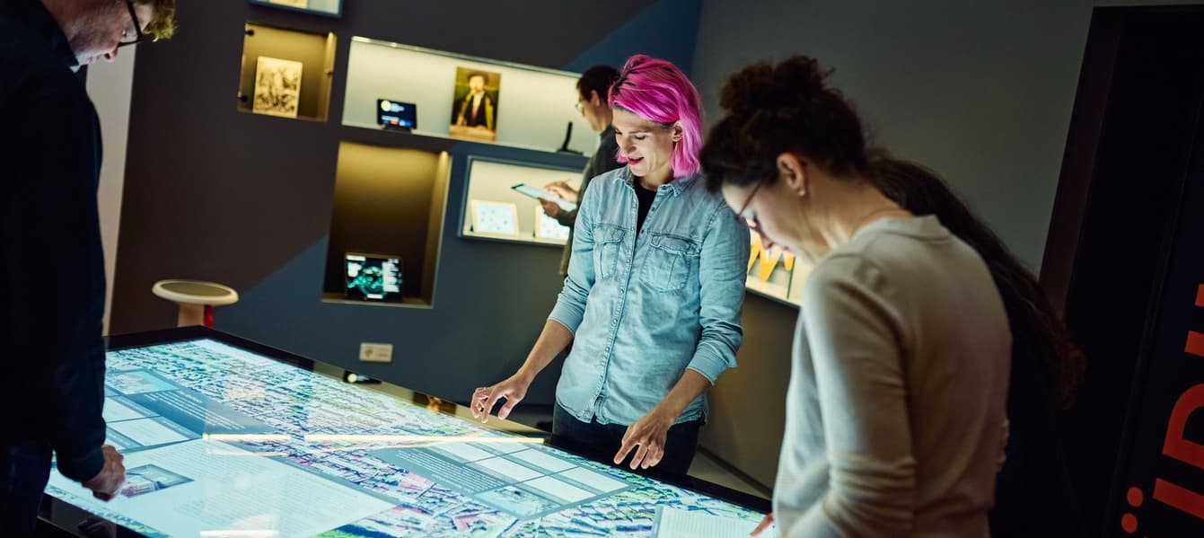 Several people working together at a multi-touch table in the IWM